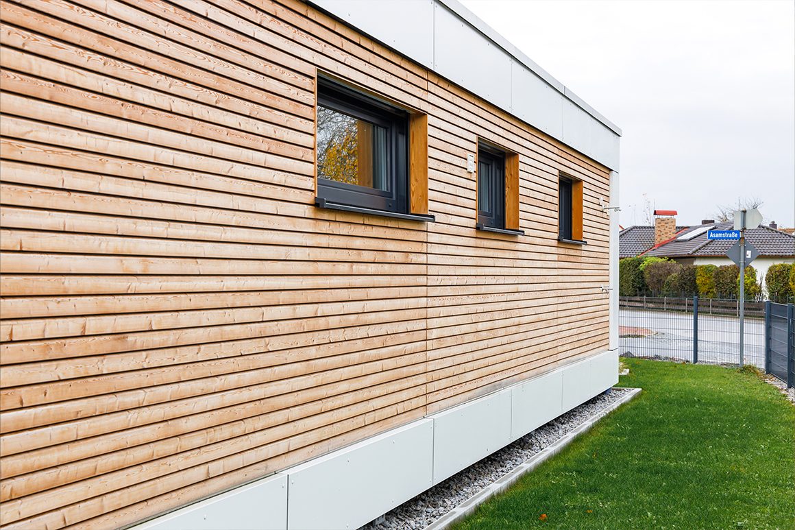 Das Modulhaus ist zur Straßenseite mit hohen, kleinen Fenstern ausgestattet. 