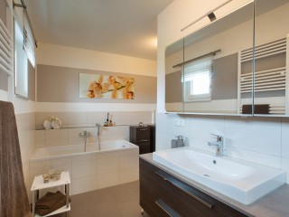 Geschickt geplant: Das WC versteckt sich hinter der Wand vom Waschtisch. Wolf – Haus Kugler Badezimmer